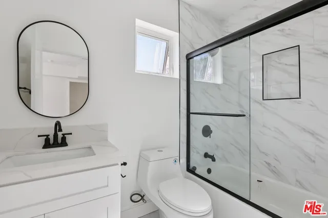 a bathroom with a toilet a sink and a mirror
