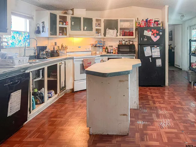 a kitchen with stainless steel appliances granite countertop a sink and a wooden floor