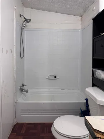 a bathroom with a toilet and a shower
