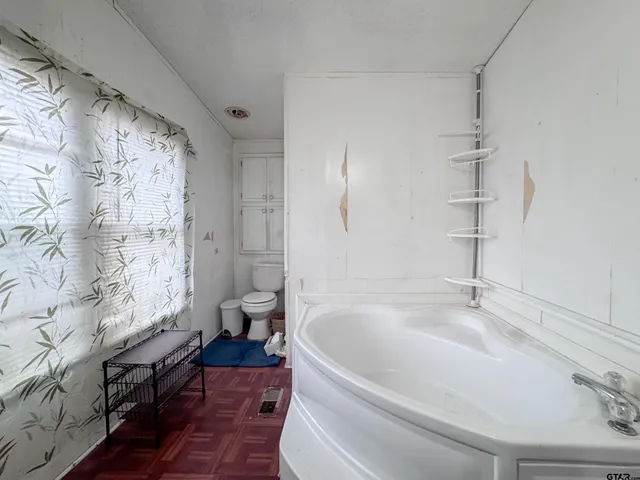 a white bath tub sitting next to a white toilet