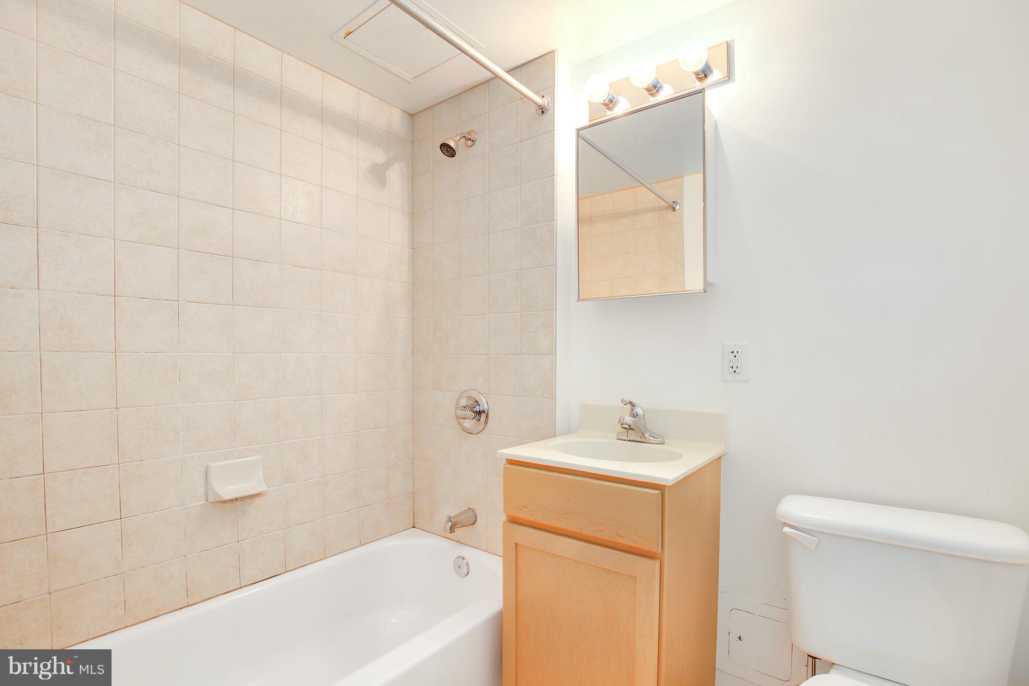 800 4th Street Southwest, Unit S113 Washington, DC 20024 - Photo 19 of 22 a bathroom with a sink a toilet and shower