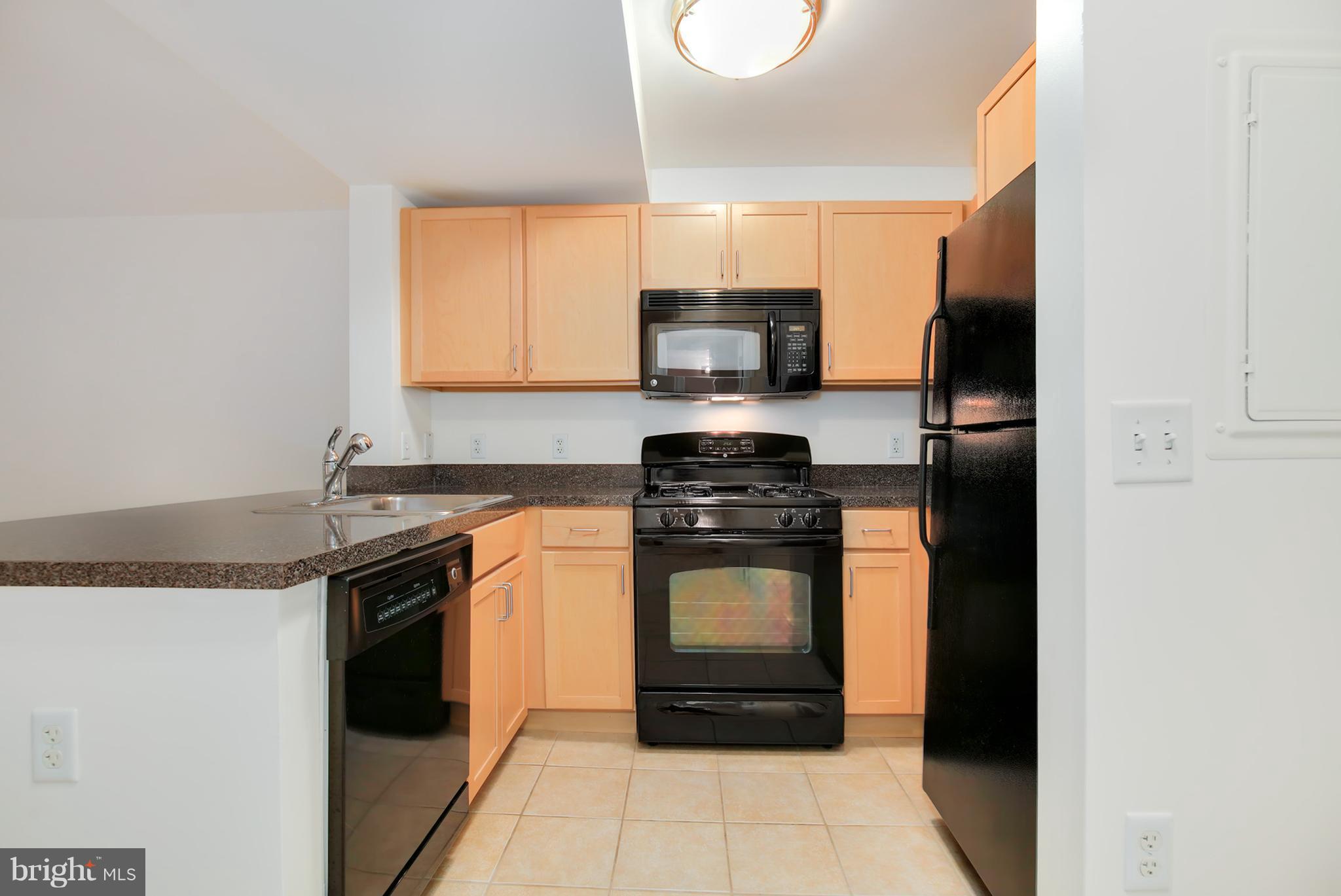 800 4th Street Southwest, Unit S113 Washington, DC 20024 - Photo 4 of 22 a kitchen with stainless steel appliances granite countertop a stove a sink and a microwave