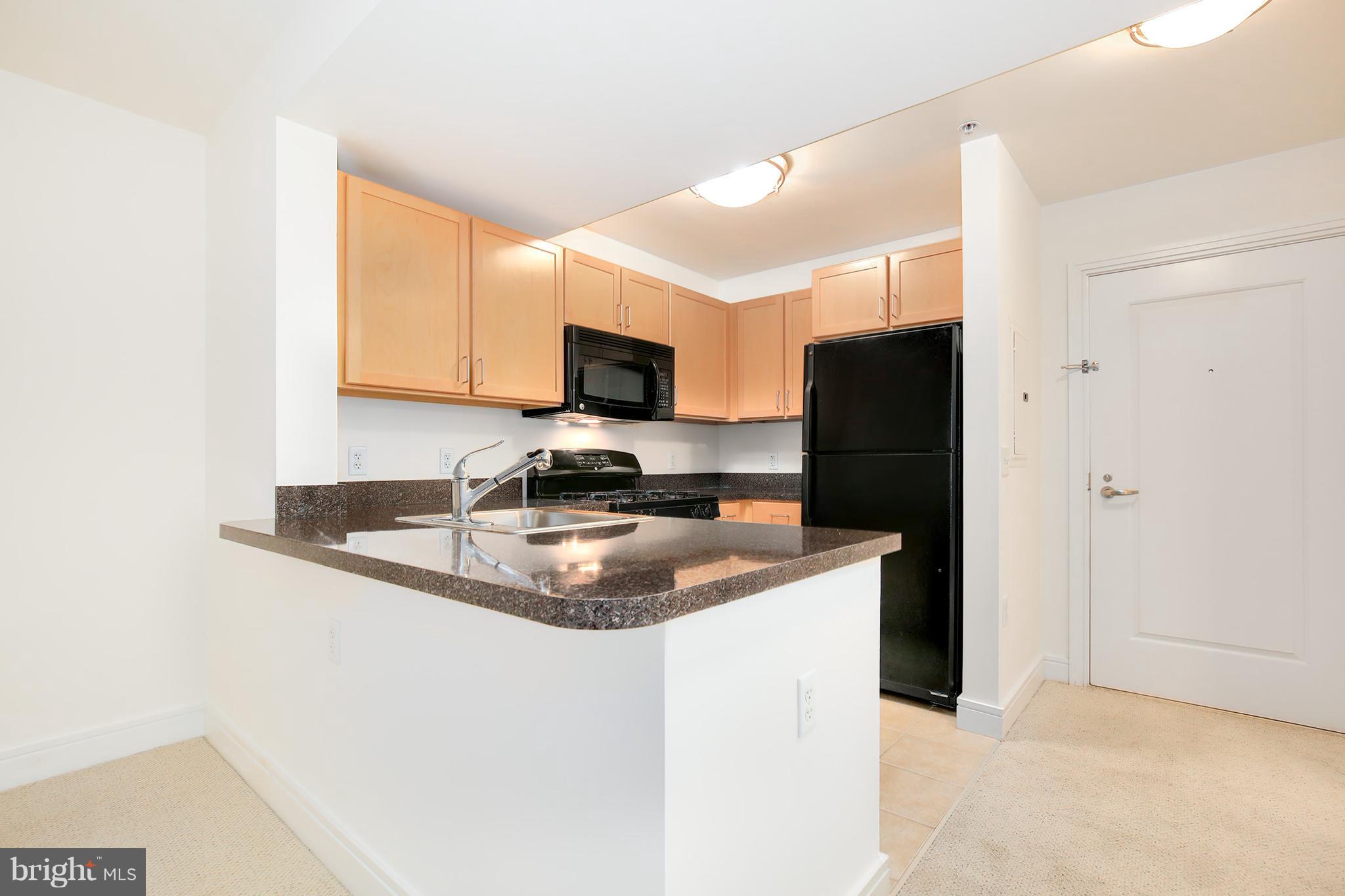 800 4th Street Southwest, Unit S113 Washington, DC 20024 - Photo 7 of 22 a kitchen with stainless steel appliances granite countertop a refrigerator a stove a sink a microwave a counter space and cabinets
