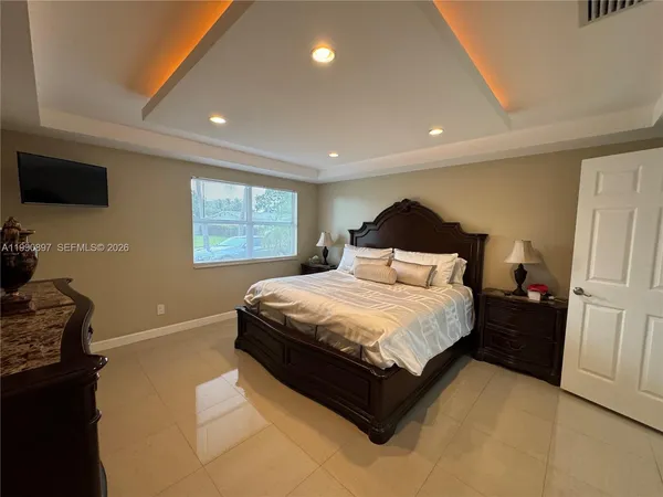 a bedroom with a bed and a flat screen tv