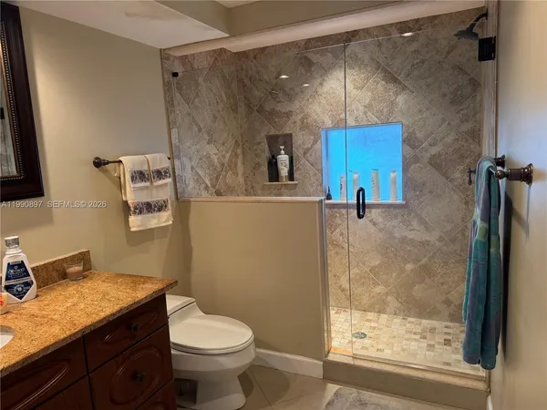 a bathroom with a granite countertop sink toilet and shower
