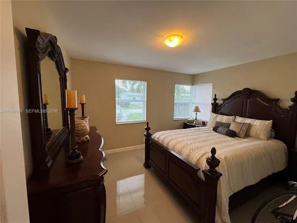 a bedroom with a bed and a flat tv screen on dresser