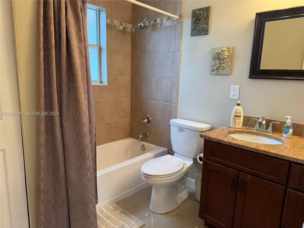 a bathroom with a granite countertop toilet sink and tub