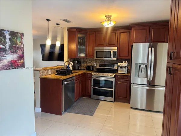 a kitchen with stainless steel appliances granite countertop a refrigerator stove and oven