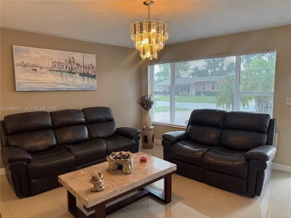 a living room with furniture a table and a large window