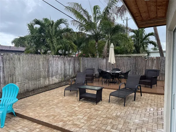 a view of backyard with outdoor seating and wooden fence