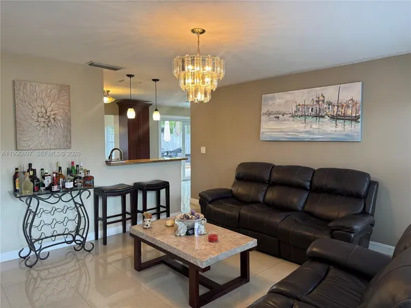 a living room with furniture a rug and a chandelier
