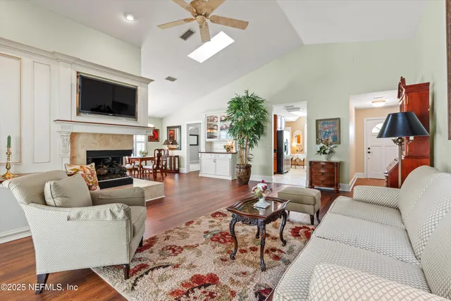 a living room with furniture a fireplace and a flat screen tv