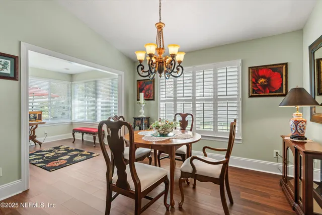 a view of a dining room with furniture and a chandelier