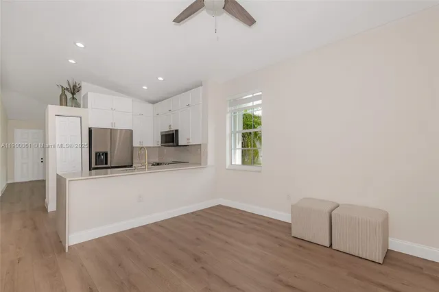 a view of kitchen with stainless steel appliances cabinets and wooden floor