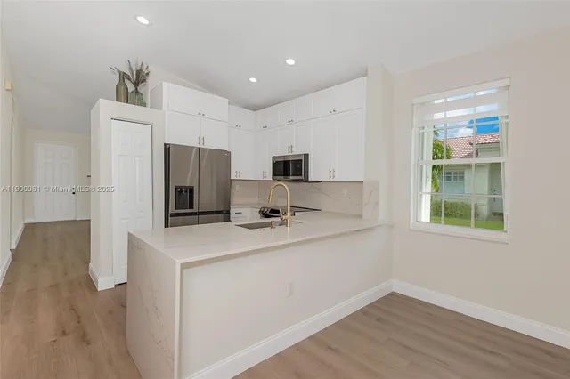 a kitchen with stainless steel appliances granite countertop a refrigerator and a sink