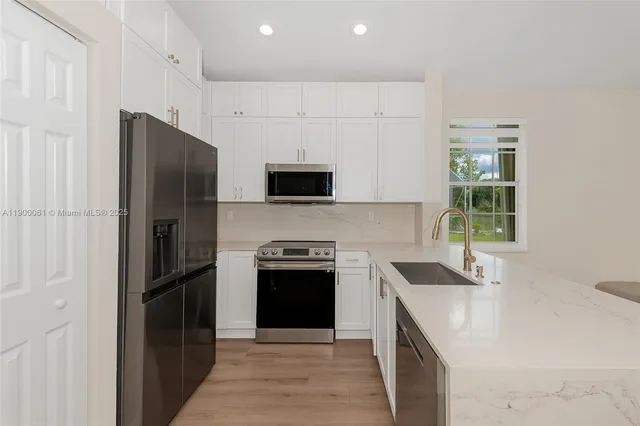a view of an empty room with wooden floor and windows