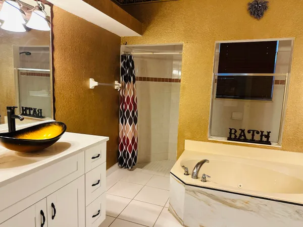 a bathroom with a tub a sink and a shower