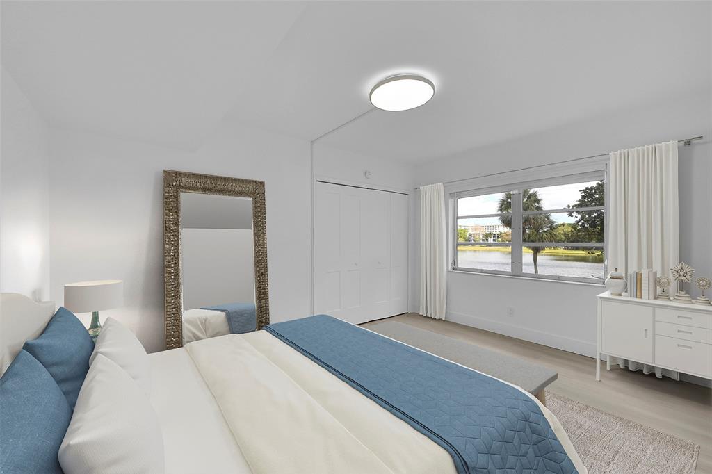 2801 North Palm Aire Drive, Unit 201 Pompano Beach, FL 33069 - Photo 12 of 19 a bedroom with a large bed and a large window