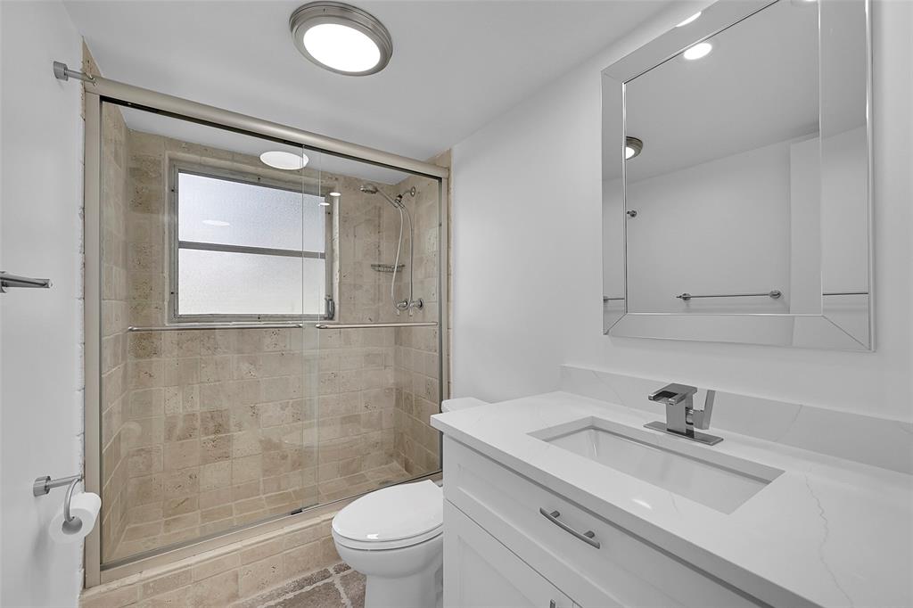 2801 North Palm Aire Drive, Unit 201 Pompano Beach, FL 33069 - Photo 13 of 19 a bathroom with a sink a toilet and shower