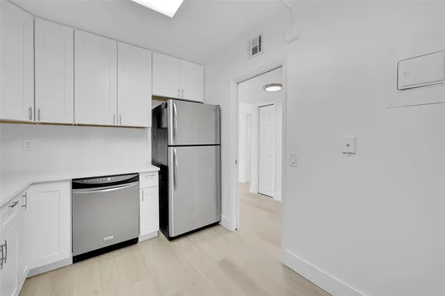 a kitchen with cabinets and stainless steel appliances