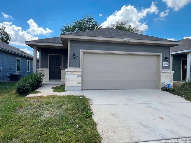 a front view of a house with a yard and garage