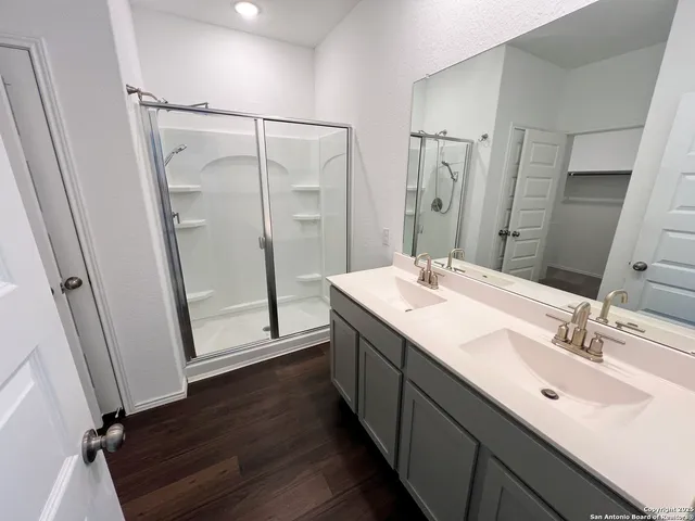 a bathroom with a double vanity sink mirror and shower