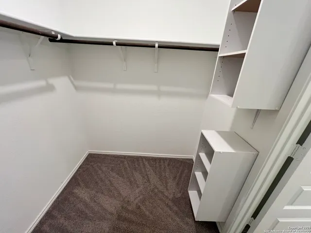 a view of walk in closet with clothes