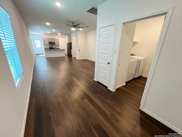 a view of a hallway with wooden floor