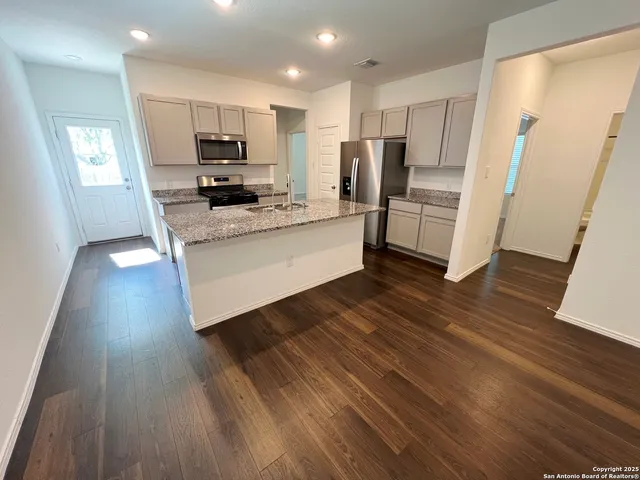 a kitchen with stainless steel appliances a refrigerator and a stove top oven