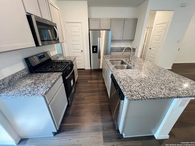 a kitchen with sink stove and refrigerator