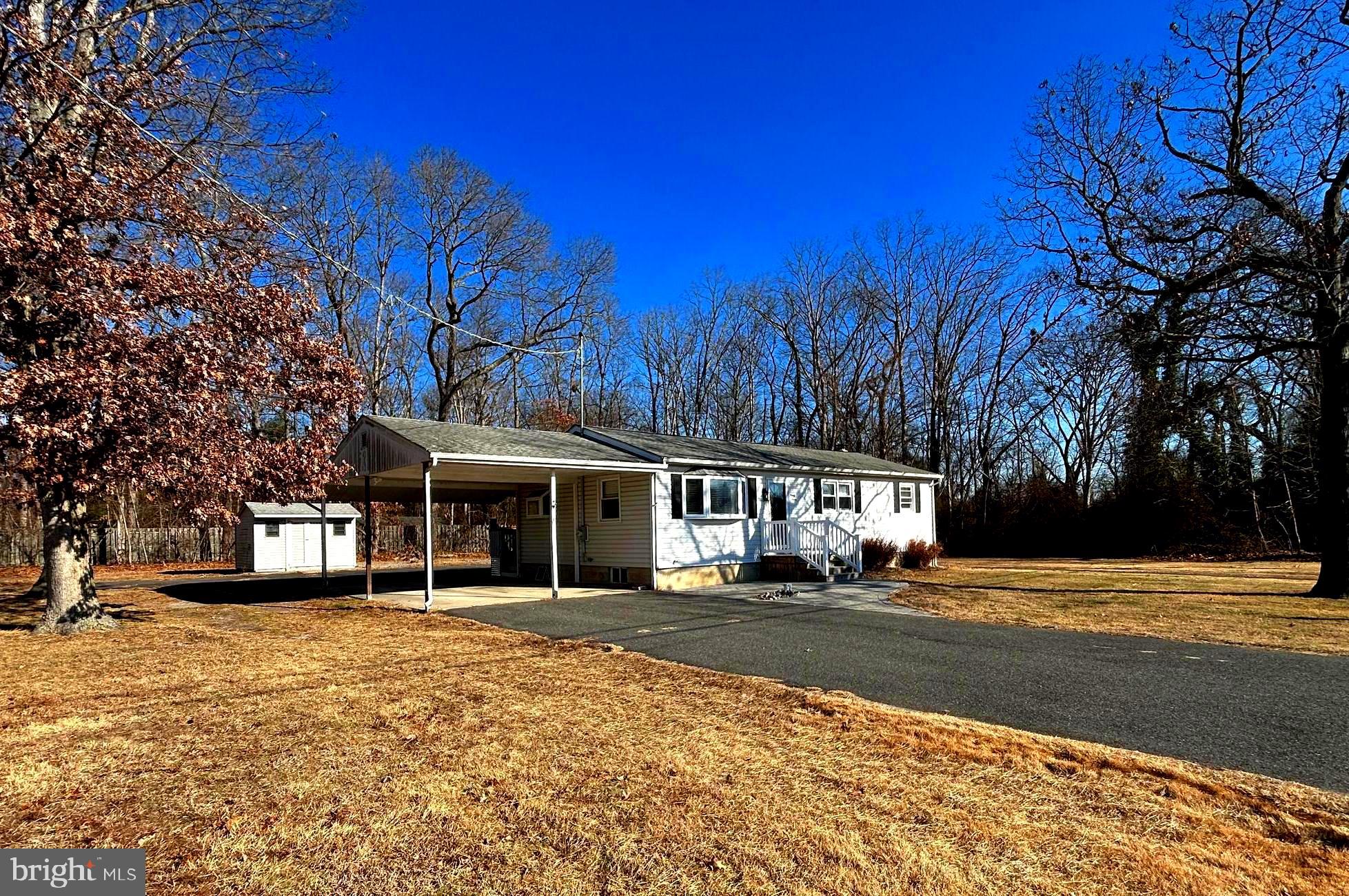 a front view of a building with a garden and trees