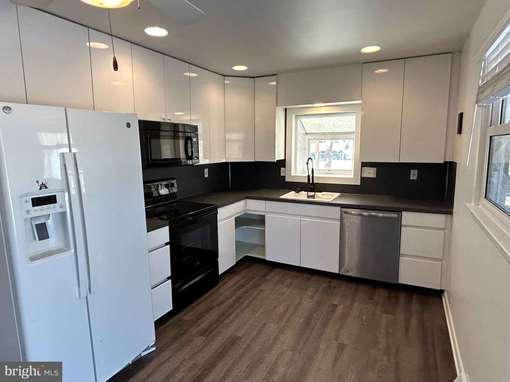 97 Sheppards Mill Road Bridgeton, NJ 08302 - Photo 16 of 27 a kitchen with a sink a refrigerator a microwave and cabinets