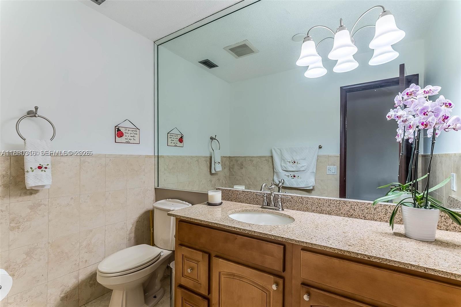 10204 Southwest 96th Court Miami, FL 33176 - Photo 17 of 54 a bathroom with a granite countertop sink a toilet and a mirror