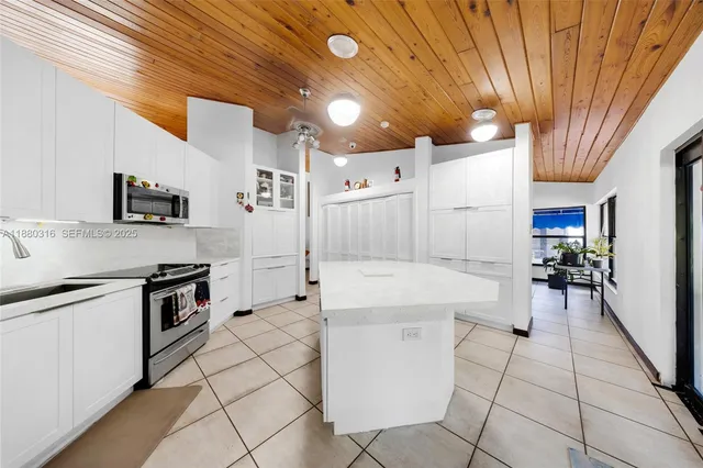 an empty room with windows and fireplace