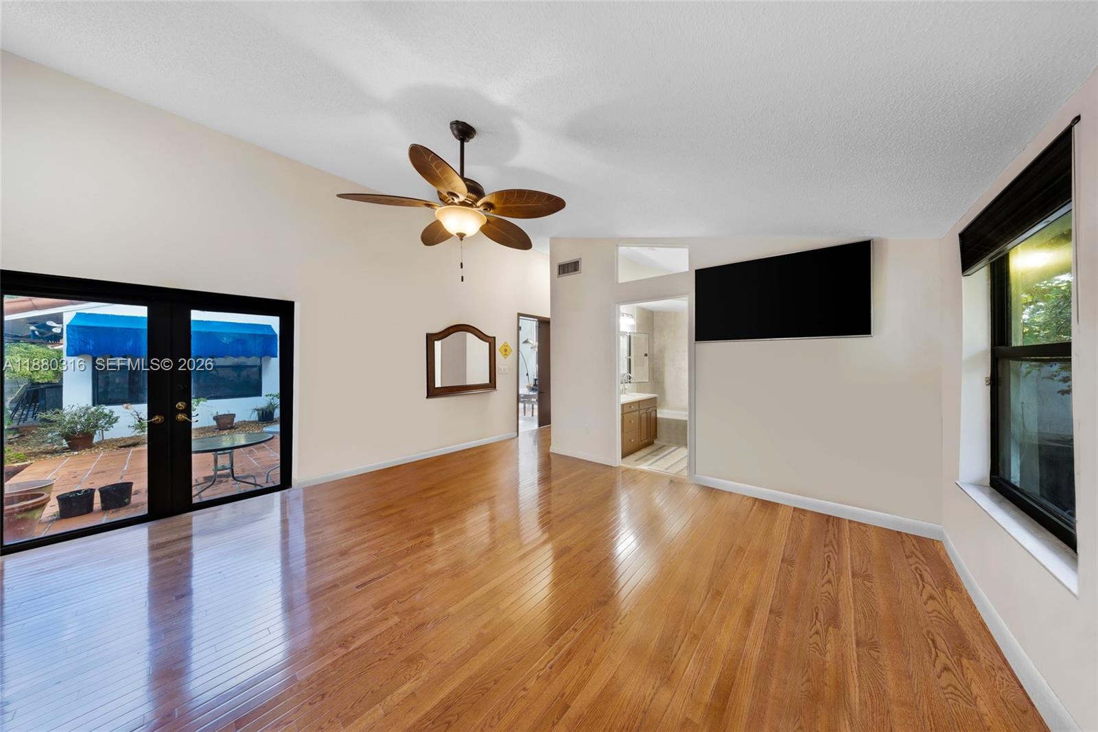 10204 Southwest 96th Court Miami, FL 33176 - Photo 23 of 54 a view of a livingroom with a flat screen tv wooden floor and a ceiling fan
