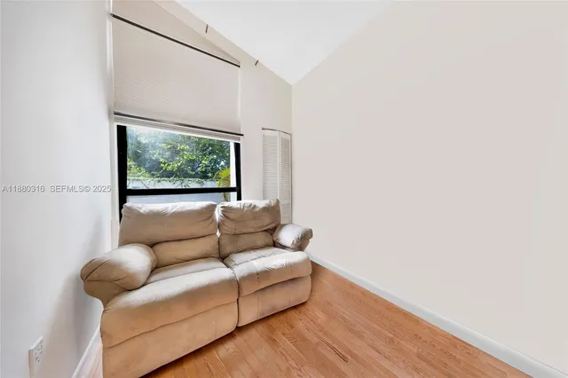 a view of a big room with windows and chandelier fan