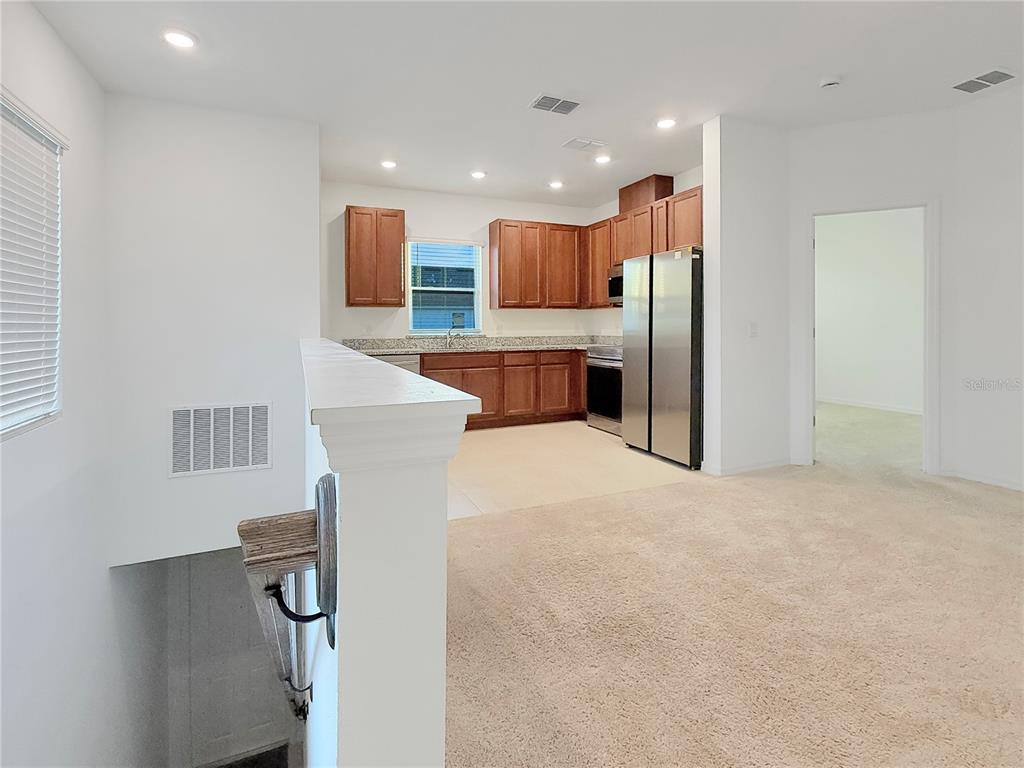 6502 Rover Way St. Cloud, FL 34771 - Photo 3 of 9 a kitchen with stainless steel appliances kitchen island sink refrigerator and microwave
