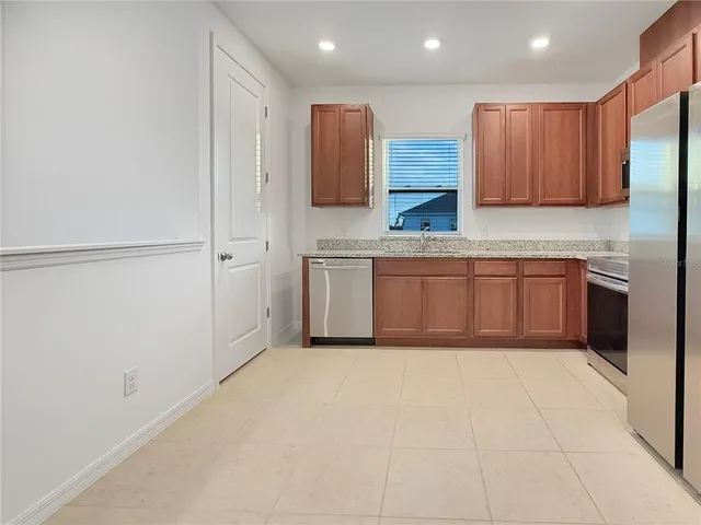 a kitchen with stainless steel appliances granite countertop a refrigerator and a sink