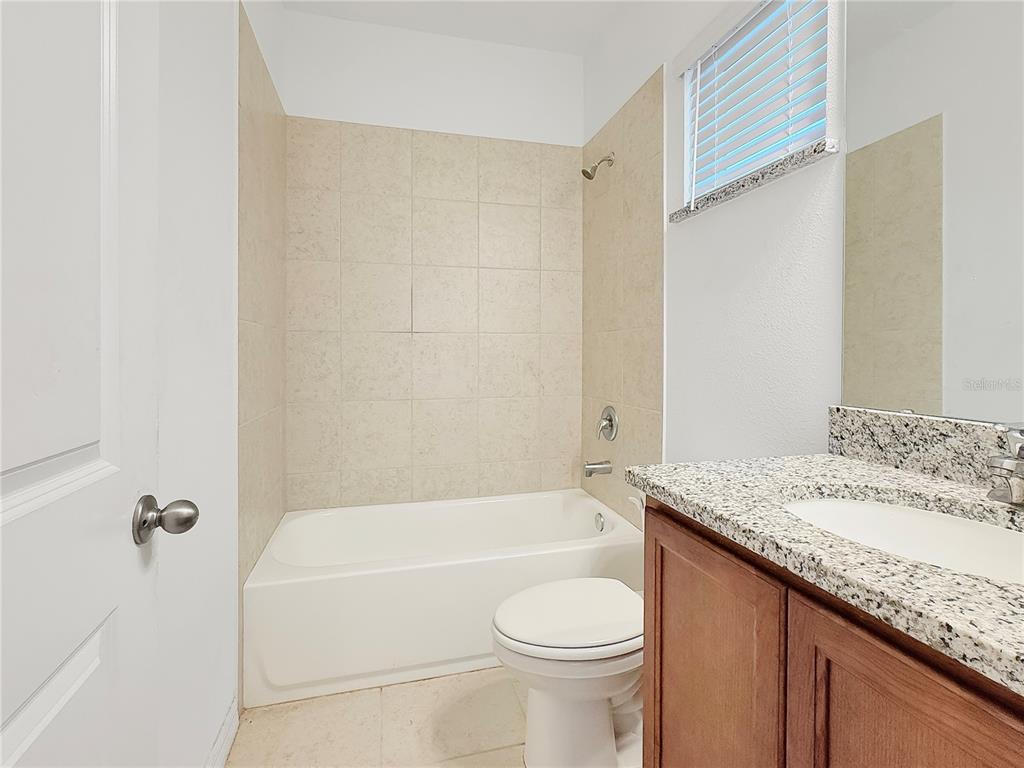 6502 Rover Way St. Cloud, FL 34771 - Photo 7 of 9 a bathroom with a granite countertop bathtub shower sink vanity and toilet