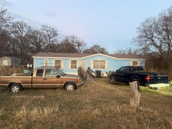a front view of a house with cars parked