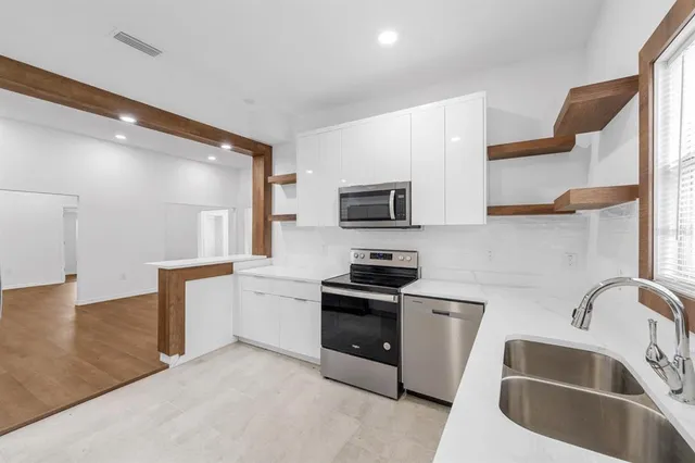 a kitchen with stainless steel appliances granite countertop a sink and a stove top oven