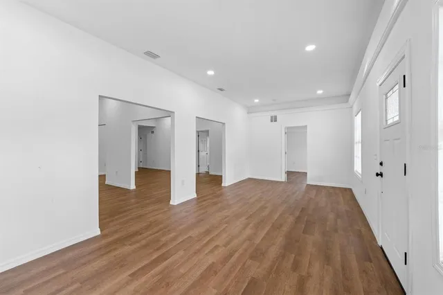 a view of an empty room with wooden floor