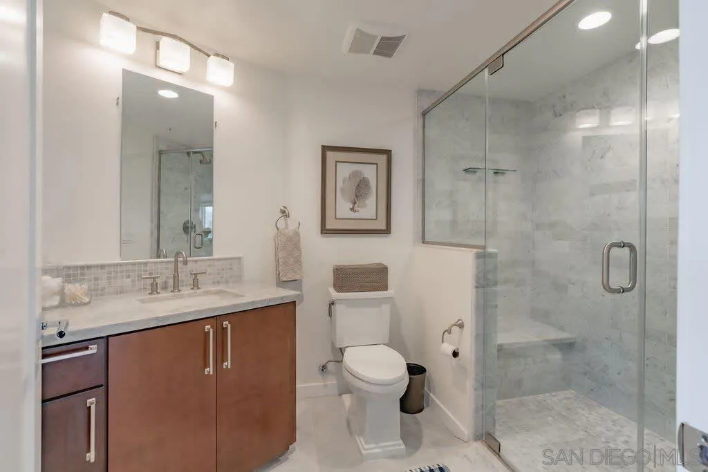 6767 Neptune Place, Unit 301 La Jolla, CA 92037 - Photo 13 of 39 a bathroom with a granite countertop sink toilet and shower