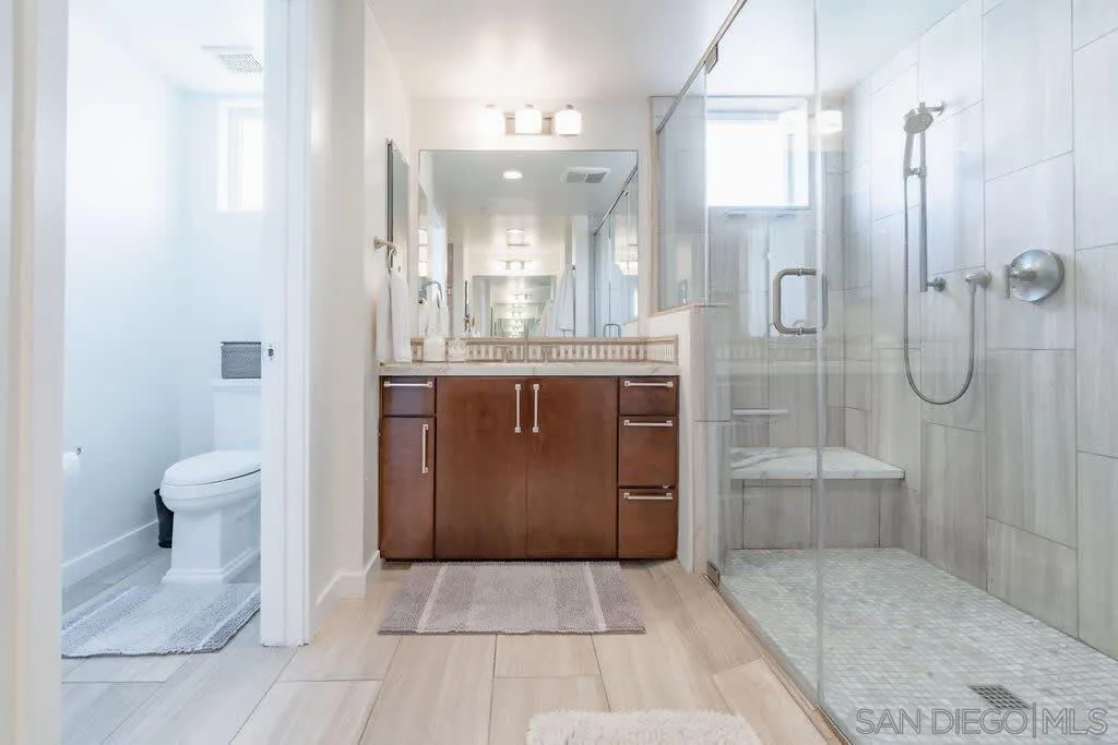 6767 Neptune Place, Unit 301 La Jolla, CA 92037 - Photo 14 of 39 a bathroom with a granite countertop sink a toilet and shower