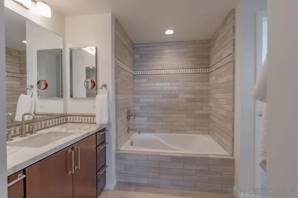 6767 Neptune Place, Unit 301 La Jolla, CA 92037 - Photo 17 of 39 a bathroom with a shower sink and mirror