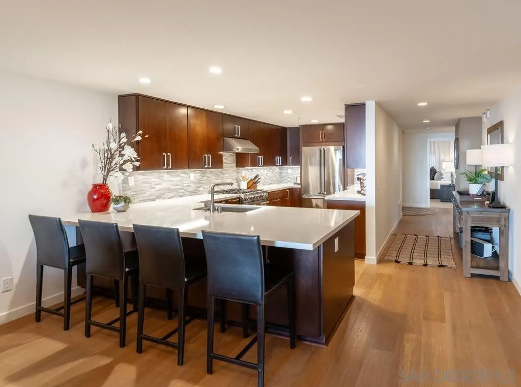 6767 Neptune Place, Unit 301 La Jolla, CA 92037 - Photo 19 of 39 a dining hall with stainless steel appliances kitchen island granite countertop a dining table chairs and a refrigerator
