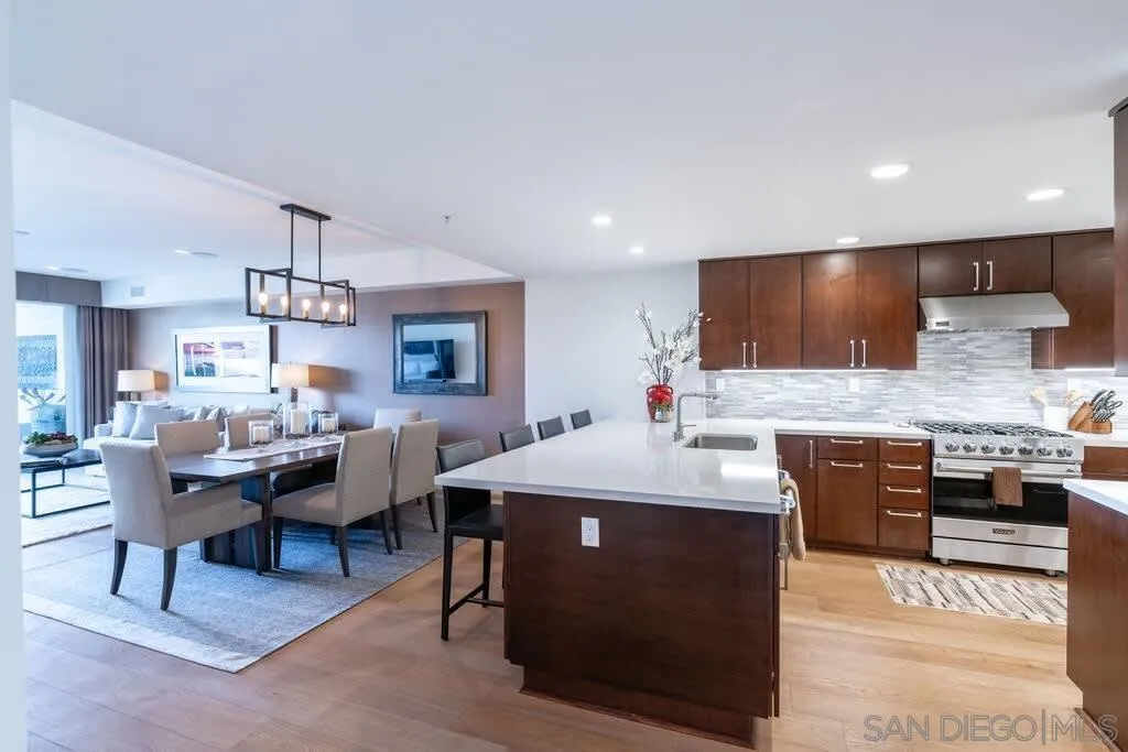 6767 Neptune Place, Unit 301 La Jolla, CA 92037 - Photo 22 of 39 a kitchen with stainless steel appliances kitchen island granite countertop a sink and cabinets