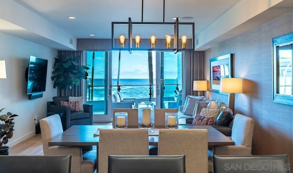 6767 Neptune Place, Unit 301 La Jolla, CA 92037 - Photo 25 of 39 a living room with furniture a lamp and a large window
