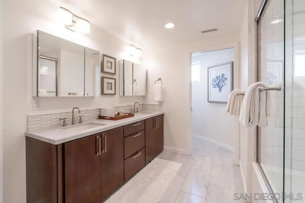 6767 Neptune Place, Unit 301 La Jolla, CA 92037 - Photo 8 of 39 a spacious bathroom with a double vanity sink a mirror and a shower