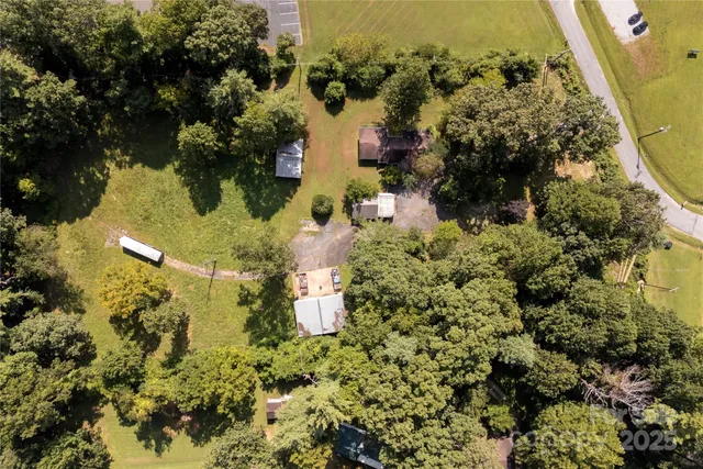 an aerial view of a residential houses with yard